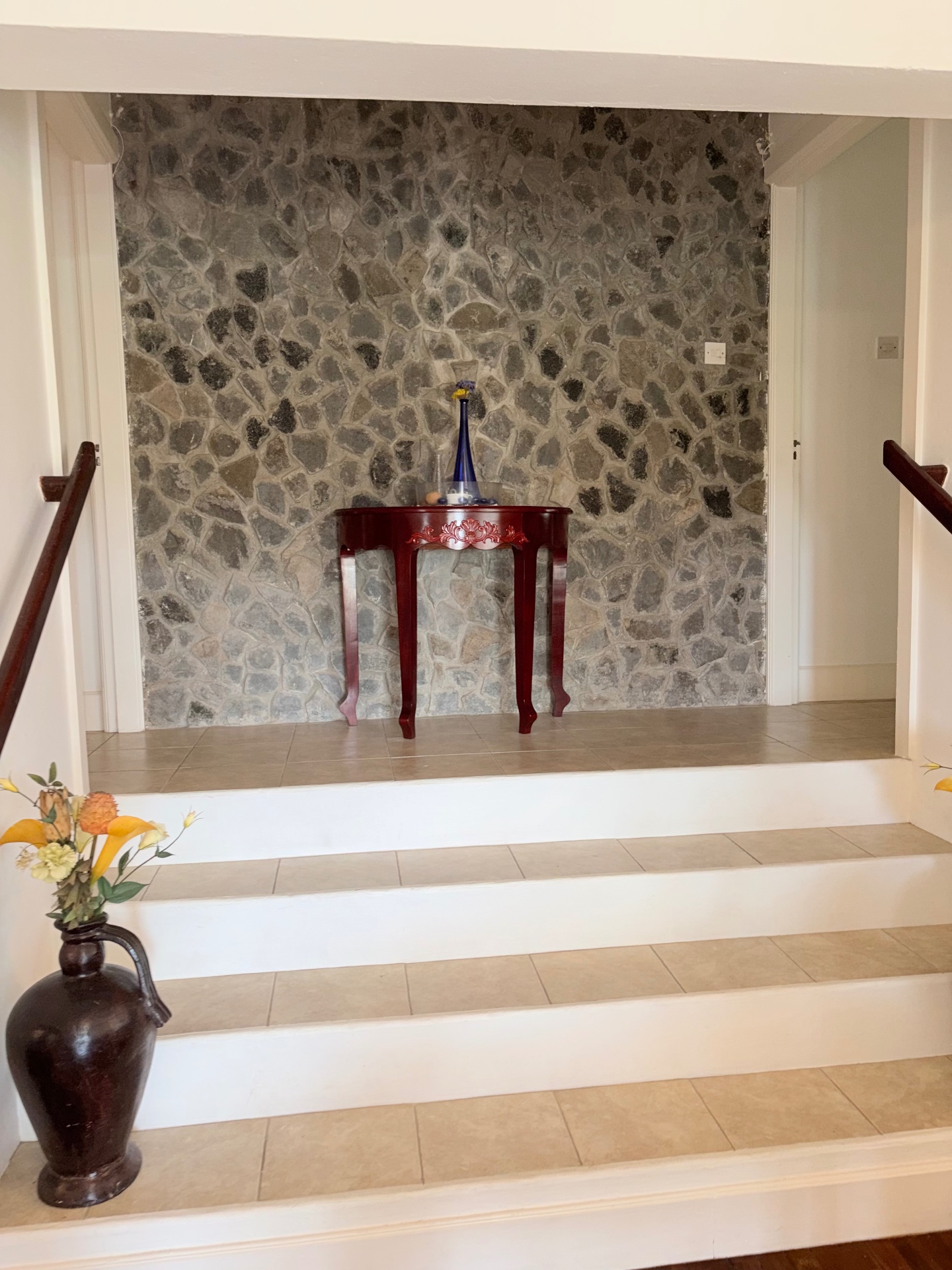 Interior foyer with stone feature wall and tiled staircase