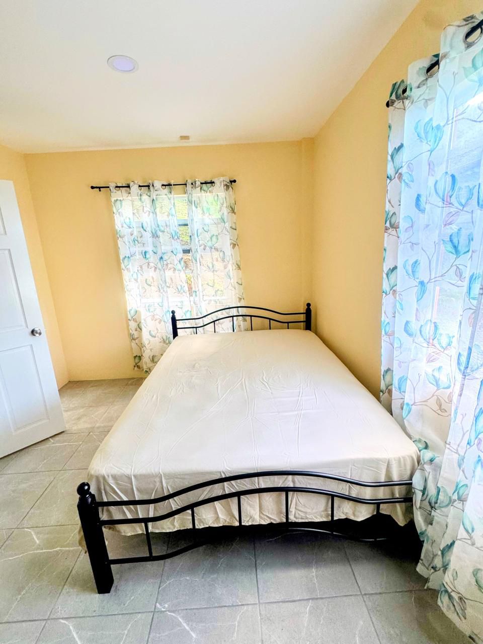 Bright primary bedroom with double bed and natural light