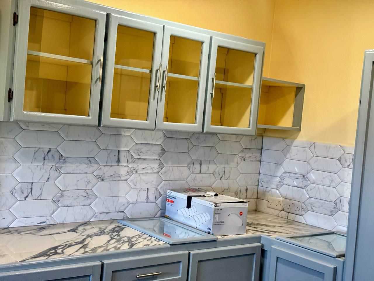 Modern kitchen with marble counters and hexagon tile backsplash