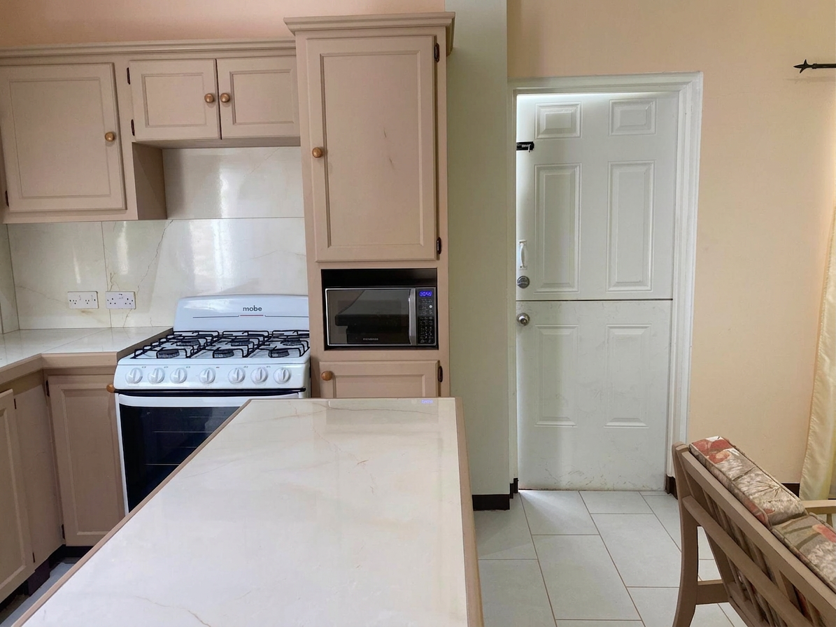 Kitchen view with gas stove, microwave and breakfast bar