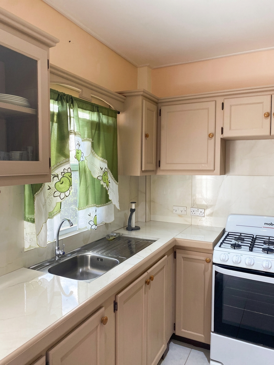 Kitchen with stainless steel sink, gas stove and natural light from window