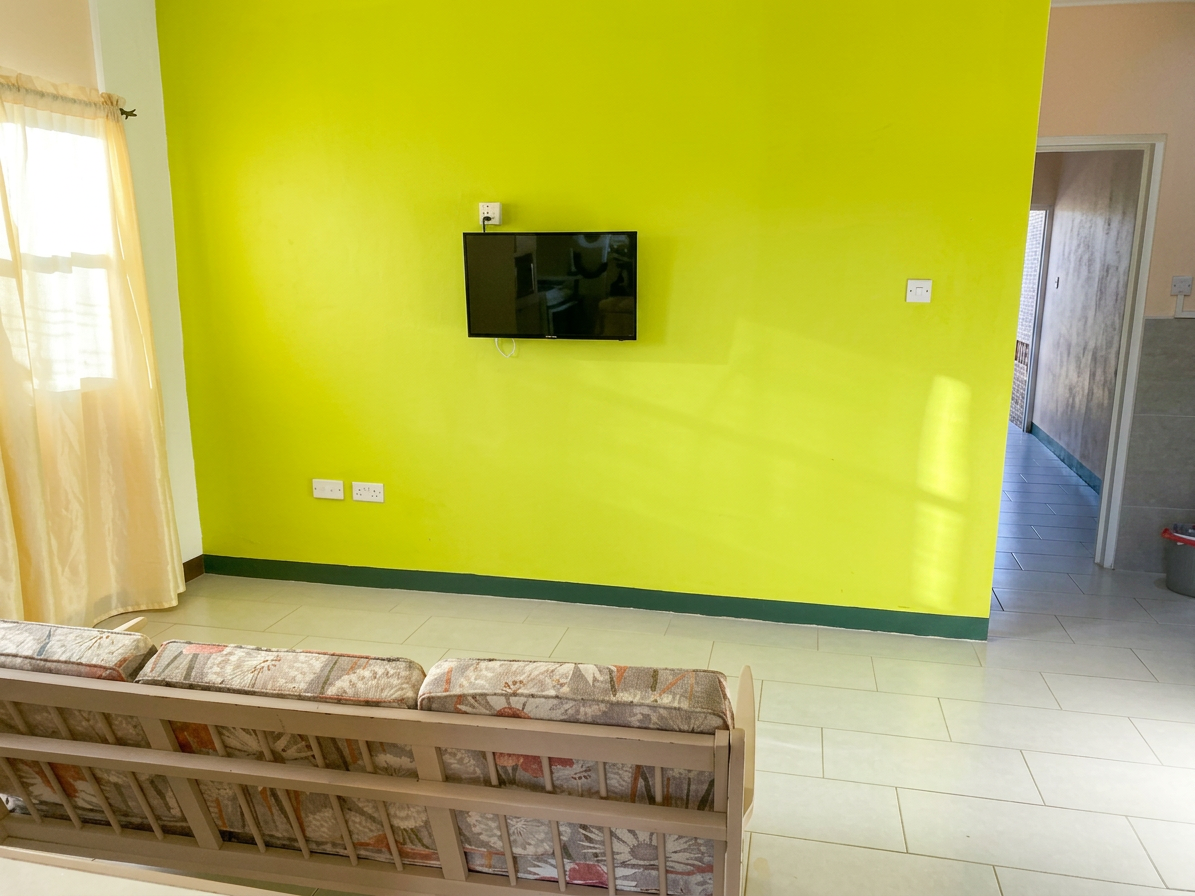 Open living area with sofa and wall-mounted TV