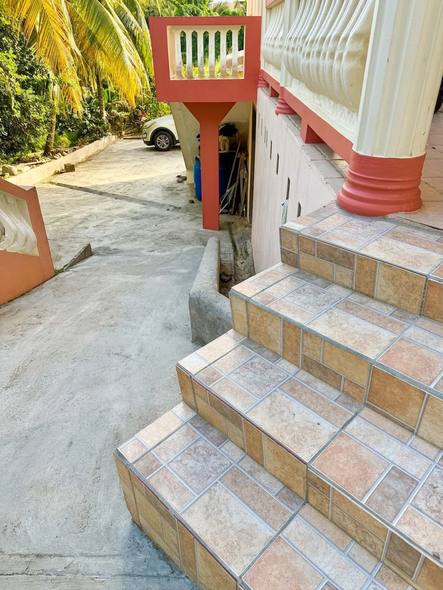 Tiled entry stairs and driveway with covered parking