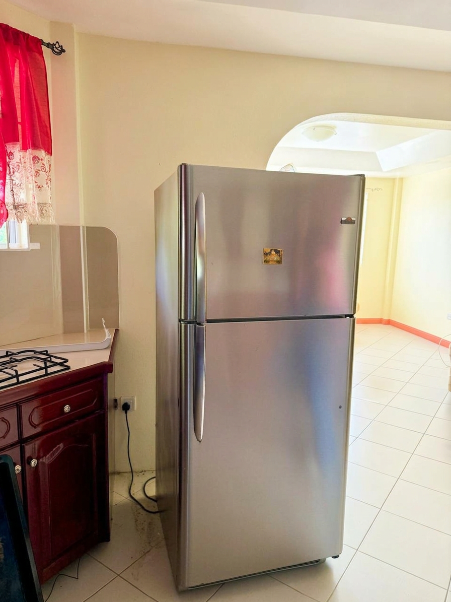 Kitchen with gas stove, full-size stainless refrigerator and wood cabinetry