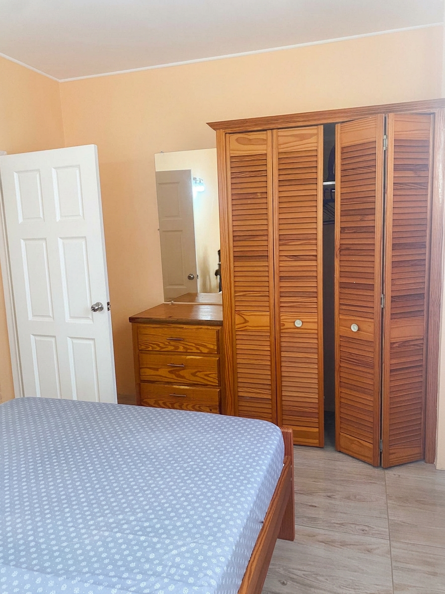 Second bedroom with built-in louvered wardrobe and dresser