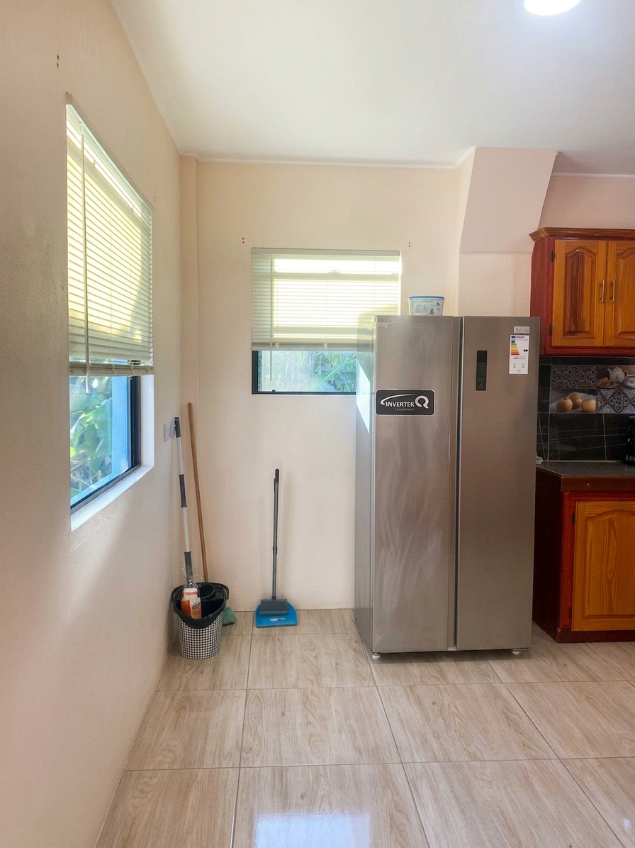 Utility nook off the kitchen with side-by-side refrigerator