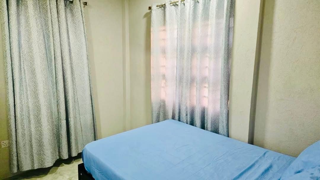 Bedroom with double bed, curtained windows and tiled floors