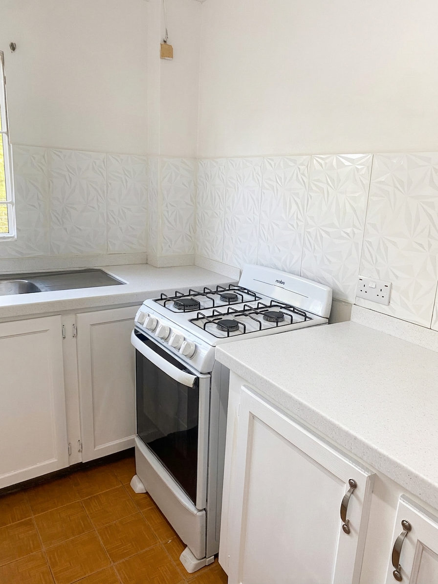 Alternate kitchen view showing counters, stove and sink area