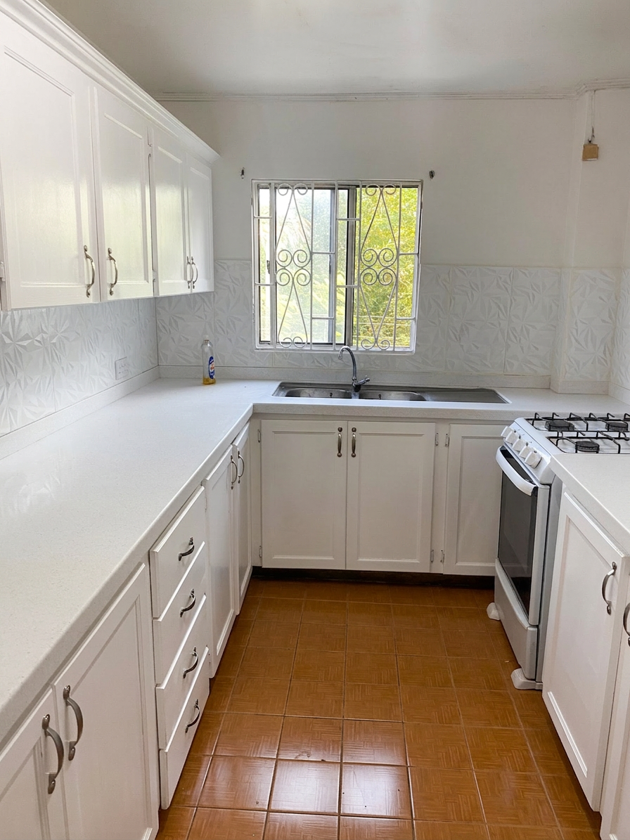 Bright kitchen with ample white cabinetry, gas stove and natural light