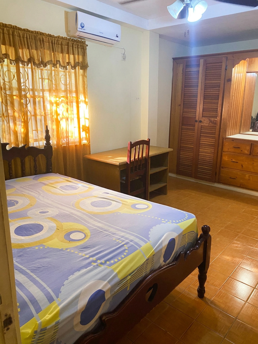 Primary bedroom with queen bed, desk and split-unit air conditioning